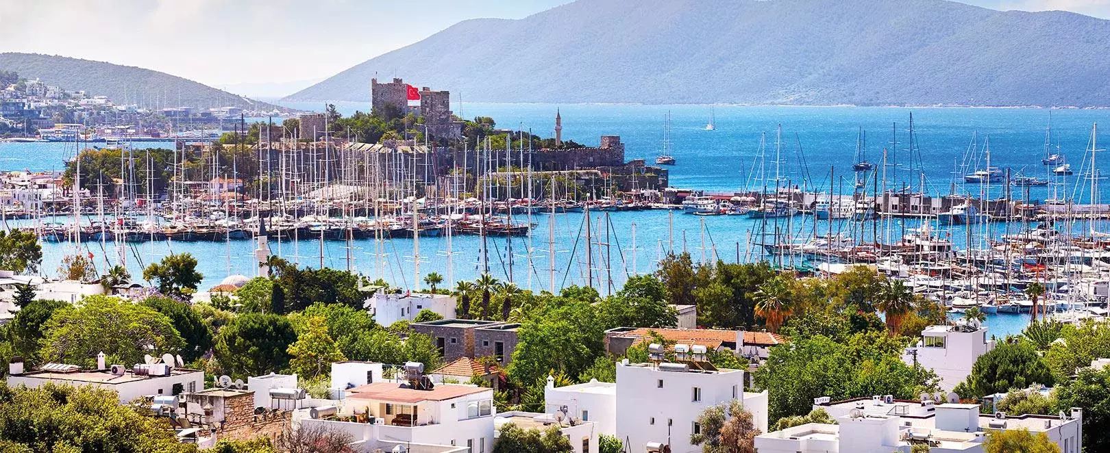 Vue générale de Bodrum avec marina et collines, station balnéaire prisée de la mer Égée en Turquie.
