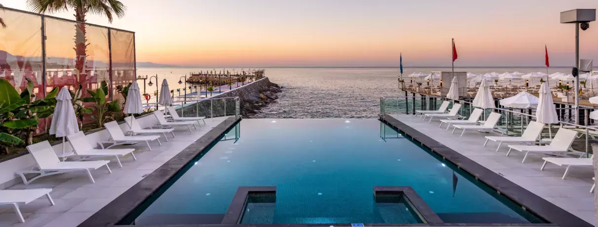 piscine en longueur avec vue sur la mer et transats