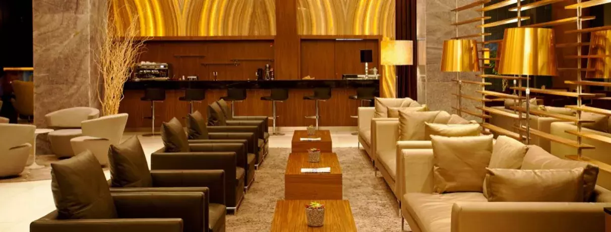 hall de l'hôtel avec bar et coin salon avec canapés et fauteuils