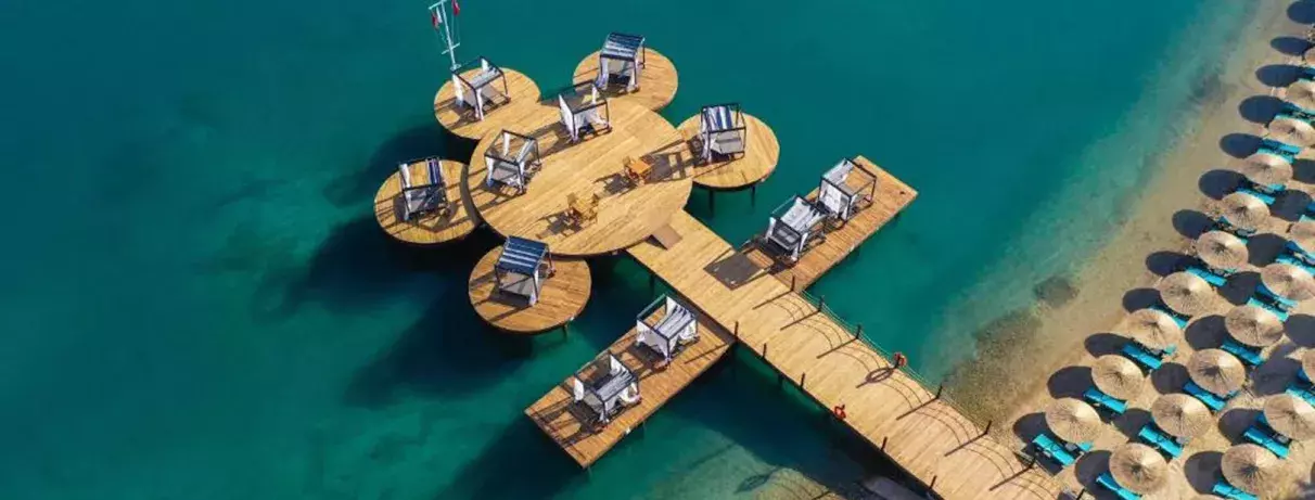 vue aérienne d’une structure en bois reliée à la plage au milieu de la mer