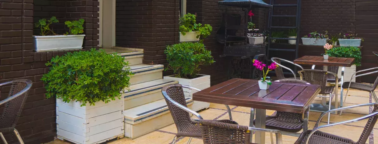 terrasse extérieure de l'hôtel avec table, chaises et plantes