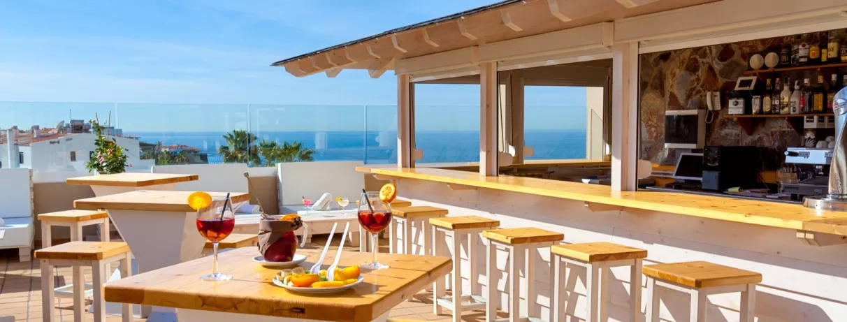 Un bar de terrasse ensoleillé offrant une vue sur l'océan.