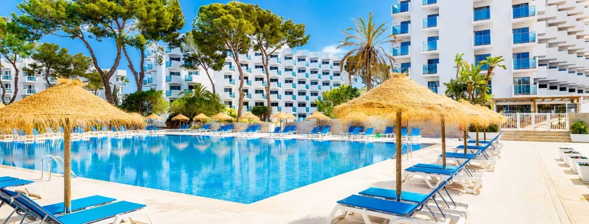 vue de la grande piscine extérieur de l'hôtel avec parasols en paille