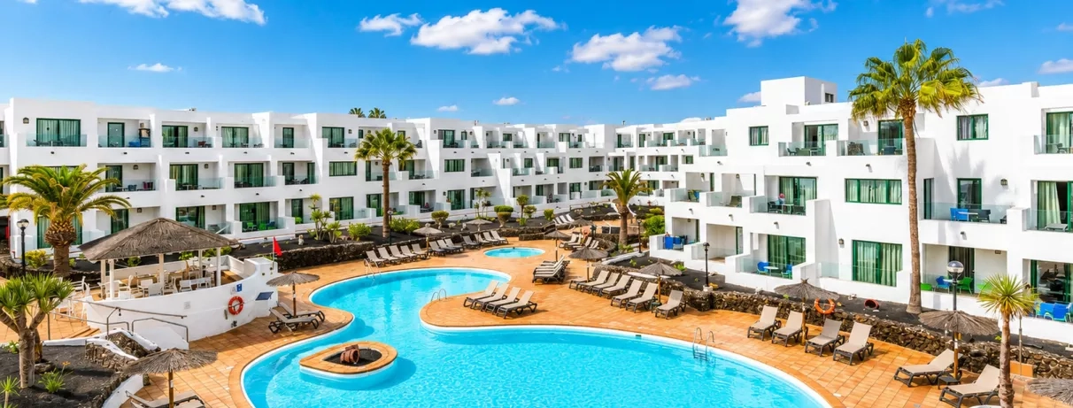 Une vue sur le complexe hôtelier, montrant la terrasses et la forme de la piscine.