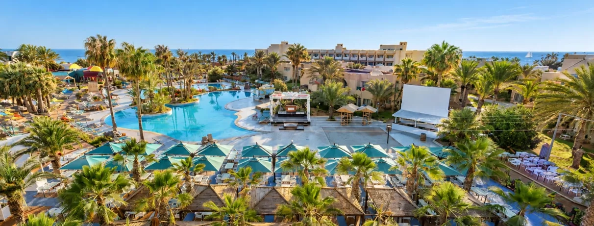 Vue aérienne du complexe hôtelier Welcome Meridiana Djerba avec piscine, scène de spectacle et palmiers