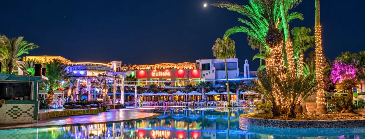 Piscine et terrasses illuminées la nuit au Welcome Meridiana Djerba hôtel tout inclus