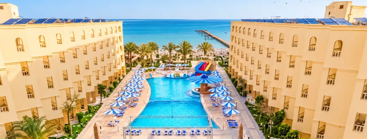 vue aérienne avec piscine plage avec transats et mer turquoise, toboggans au AMC Royal à Hurghada, Egypte