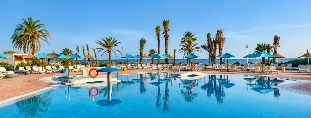 piscine principale avec palmiers et transats au vincci helya beach monastir en tunisie