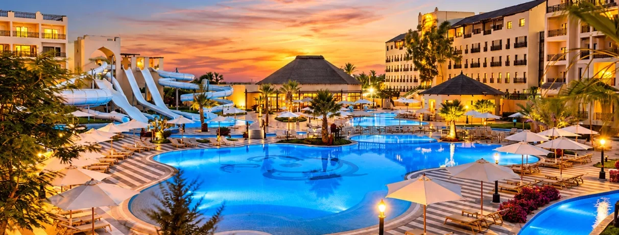 Voyage all inclusive au Steigenberger Aqua Magic Hurghada avec piscines éclairées et toboggans en soirée.