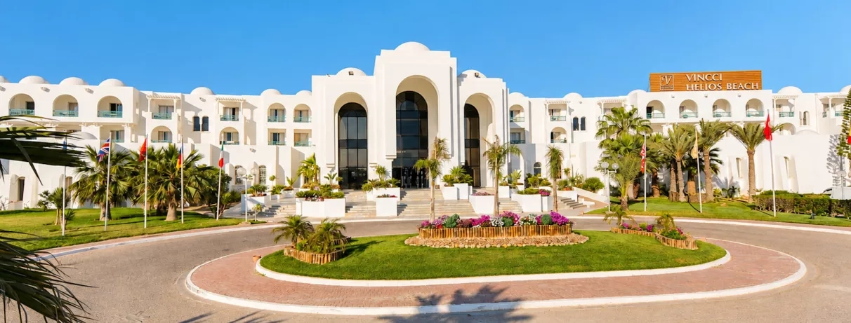 Entrée principale monumentale de l'hôtel Vincci Helios Beach entourée de jardins exotiques pour un voyage luxueux.