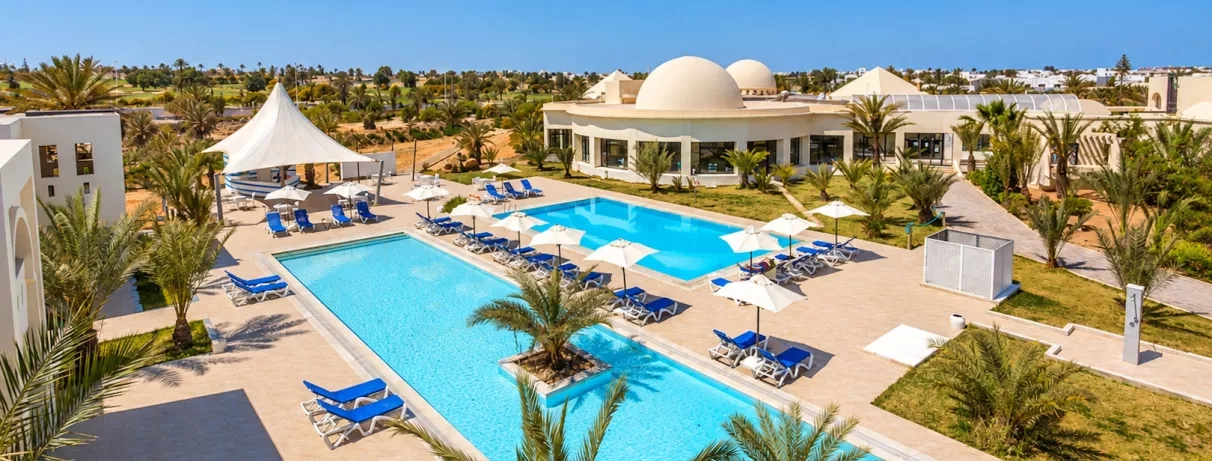 Vue aérienne des jardins et piscines turquoise de l'hôtel César Thalasso, destination de voyage à Djerba.