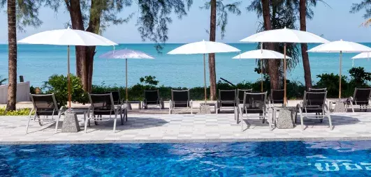 piscine extérieur avec transats et parasols et vue mer en fond