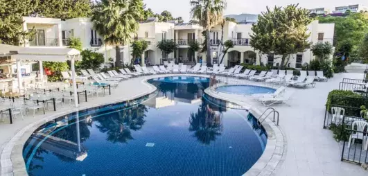 piscine extérieure avec transats et vue sur la façade de l'hôtel