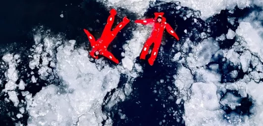 Vue aérienne, combinaisons rouges flottant sur glace fragmentée.
