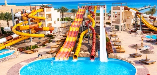 Parc aquatique avec grands toboggans colorés et piscine de l'hôtel El Karma Aqua Beach Resort à Hurghada, Égypte.