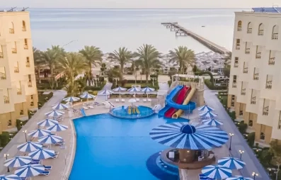 vue de haut de l'hôtel avec le bâtiment et la piscine au milieu, toboggans, transats, soleil, 