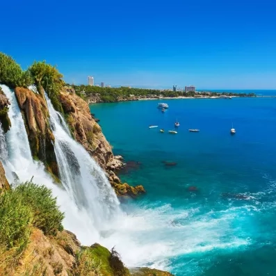chute d'eau se jetant dans la mer avec une montagne
