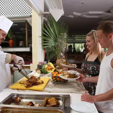 cuisinier servant des clients au buffet