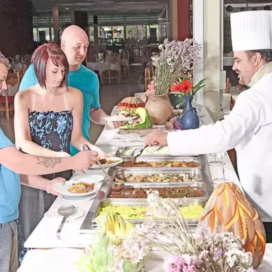 cuisinier servant des clients au buffet