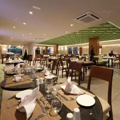 restaurant de l'hôtel avec chaises beige et tables dressées