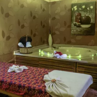 espace de détente avec une table de massage et un jacuzzi