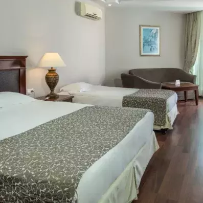 chambre avec un lit double et un lit simple avec un canapé