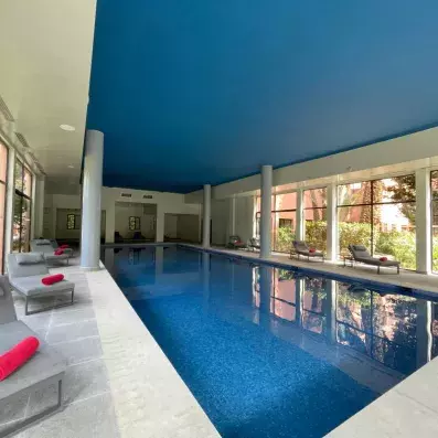 La piscine couverte de l'hôtel chauffée avec des transats et des serviettes