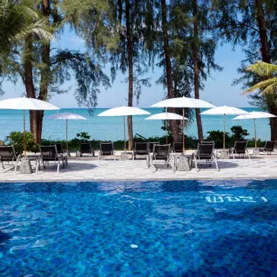 piscine extérieur avec transats et parasols et en fond la mer