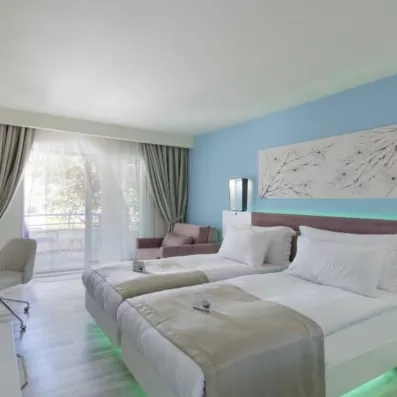 Une chambre lumineuse, avec deux lits jumeaux et d'un accès direct à un balcon privé.