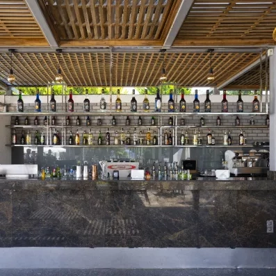 Un bar extérieur avec un comptoir en marbre et une impressionnante rangée de bouteilles.