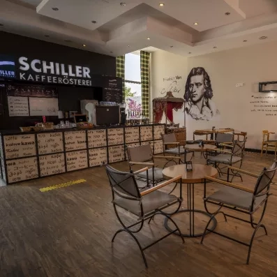 Un café chaleureux au style rétro, une banque d'accueil décorée de lettrages multilingues.