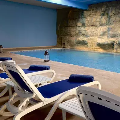 piscine intérieure chauffée avec des transats au bord de la piscine