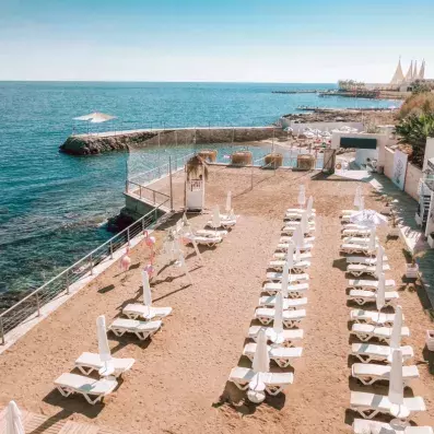 plage avec transats et parasols vue face à la mer
