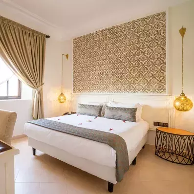 lit double en draps blancs et en tête de lit sous forme de tableau avec une ambiance épurée