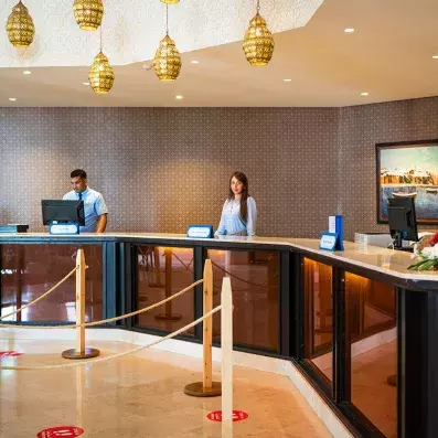 réception de l'hôtel avec personnel et lustres décoratifs accrochées au plafond