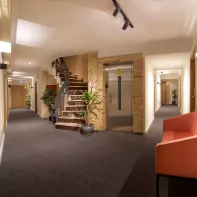 couloir de l'hôtel avec un canapé et un escaliers ainsi qu'un ascenseur