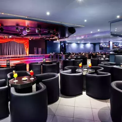 bar avec fauteuils noirs et scène