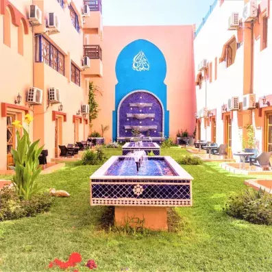 Patio avec jardi au milieu et deux fontaines d'eau avec le bâtiment des chambres tout autour