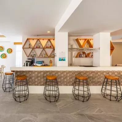 bar intérieur de l'hôtel avec comptoir et chaises hautes