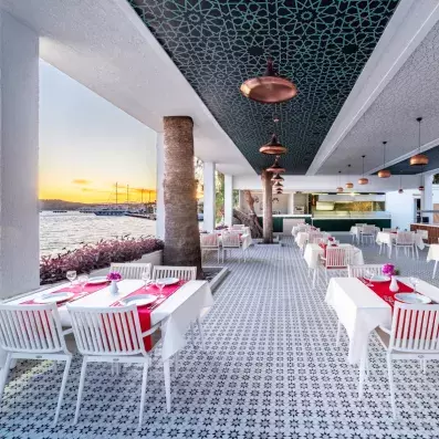 salle de restaurant sur la terrasse vue sur un coucher de soleil sur la mer