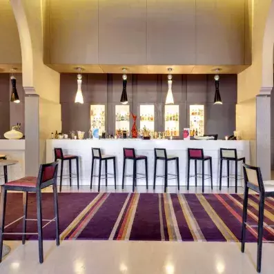 bar de l'hôtel avec des chaises hautes en rouge et blanc et des lampes en noir et blanc