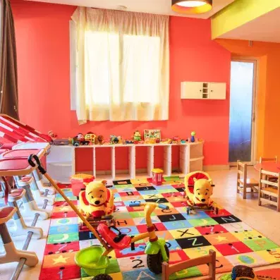 mini club pour enfant avec un tapis coloré et des jeux