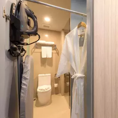 pièce avec un toilette et un peignoir et un aspirateur