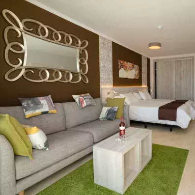 chambre avec un lit double avec canapé et table basse