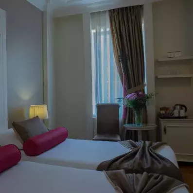 chambre avec deux lits simples et fauteuils