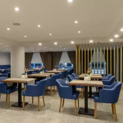 salle de restaurant avec tables et fauteuils bleus