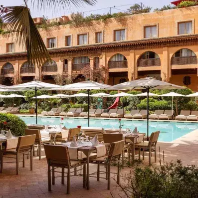 restaurant sur la terrasse avec des tables et des chaises donnants sur la piscine