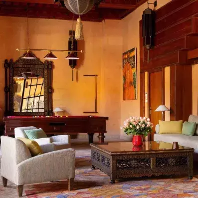 salle de loisirs, avec billards, salon beige et tapis coloré