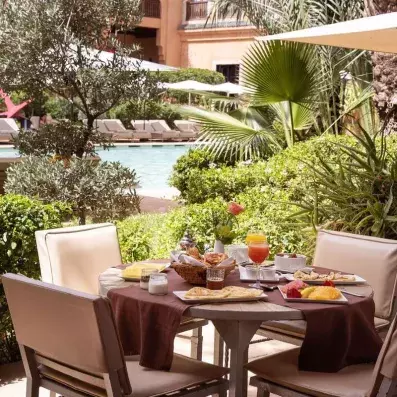 table dressée avec des chaises sur la terrasse sur la piscine