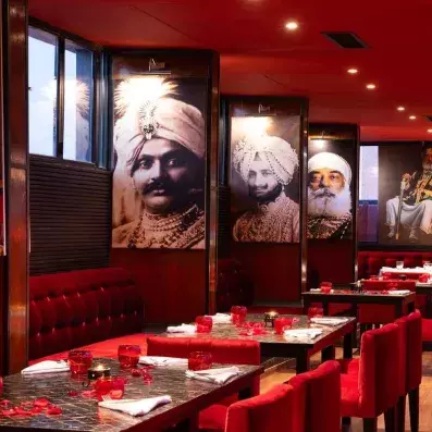 tables de restaurant rouge avec un style indien et des tableaux accrochées